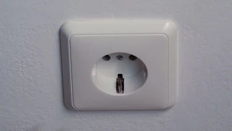 Hand puts a power plug in the wall socket Video stock 88387380