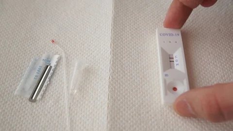 A hand puts an rapid coronavirus test on a napkin. The test result is positive Stock Footage 128767539