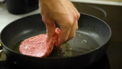 Hand puts raw burger cutlet to fry in frying pan 스톡 동영상 232892665