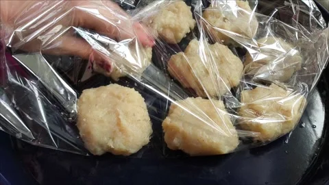 A hand puts raw chicken cutlets in a baking sleeve on a baking sheet Vídeo Stock 311843691
