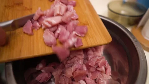 Hand puts raw chopped meat into an iron bowl. Видео 144391082