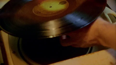 A hand puts a Record on the Record Player 1970s Stock Footage 272386827