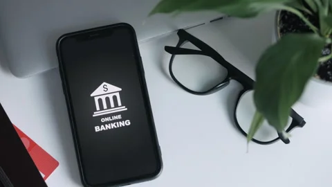 A hand puts a smartphone with an image of online banking on a white table Stock Footage 268983756