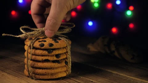 Hand puts a stack of chocolate chip cookies on wooden table. christmas concept Stock Footage 166423718