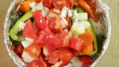 Hand puts on the table and poured olive oil fresh chopped vegetables in baking Stock Footage 319027251