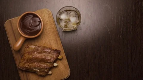 Hand puts on the table a glass of whiskey with ice. top view Stock Footage 73798099