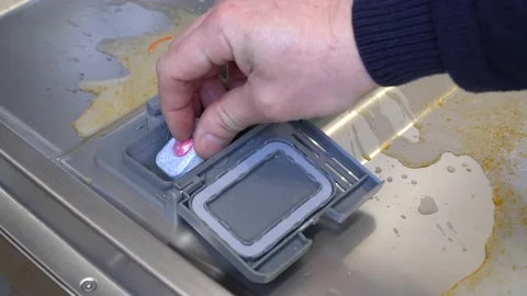 Hand puts a tablet of detergent in the dishwasher Stock Footage 149577502