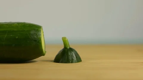 Hand puts the tail of the cucumber on the table Stock Footage 128917715