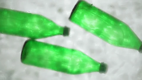 Hand puts three green bottles of water or soda in a ice water, bottom view. Stock Footage 149193069