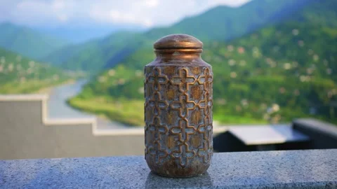 The hand puts the urn for ashes close-up on the background of beautiful Video stock 247115796
