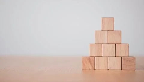 Hand putting and stacking blank wooden cubes on table with copy space Stock Photos