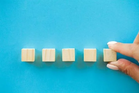Hand putting and stacking blank wooden cubes on table with copy space for input Foto stock