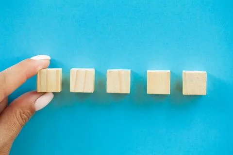 Hand putting and stacking blank wooden cubes on table with copy space for input Stock Photos