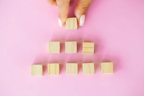 Hand putting and stacking blank wooden cubes on table with copy space for input Stock Photos
