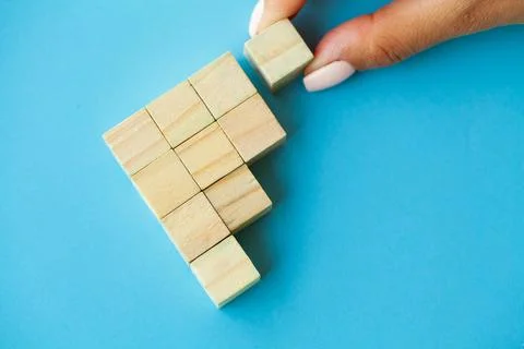 Hand putting and stacking blank wooden cubes on table with copy space for input Stock Photos