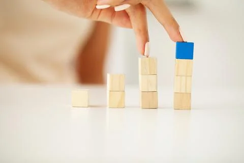 Hand putting and stacking blank wooden cubes on table with copy space for input Foto stock