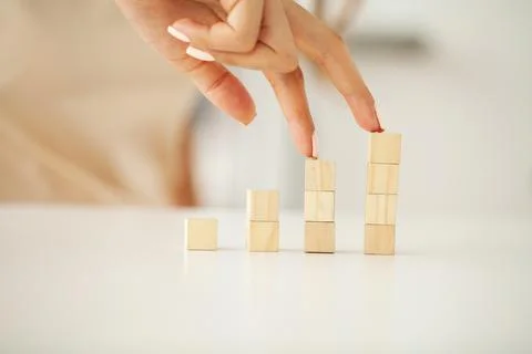 Hand putting and stacking blank wooden cubes on table with copy space for input Stock Photos