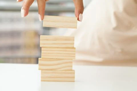 Hand putting and stacking blank wooden cubes on table with copy space for input Foto stock