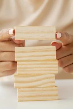 Hand putting and stacking blank wooden cubes on table with copy space for input Stock Photos