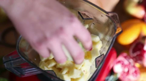 Hand putting avocado in blender with pineapple Stock Footage 59541059