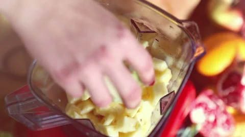 Hand putting avocado in blender with pineapple Stock Footage 59541062