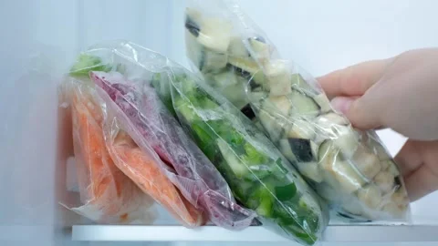 Hand putting bag of sliced eggplants in refrigerator, food storage concept. Stock Footage 290298712