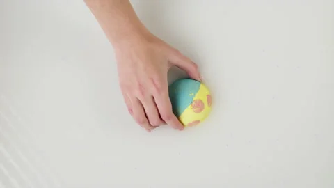Hand putting bath bomb into water close-up. Soap ball dissolving, foam bubbles Stock Footage 166314310
