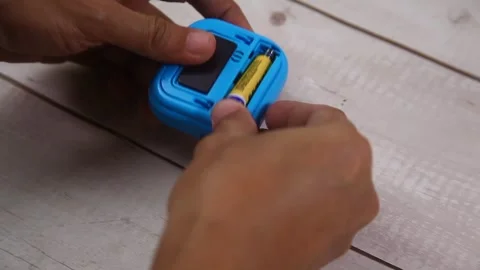 Hand putting battery in a kitchen timer Stock Footage 328403762