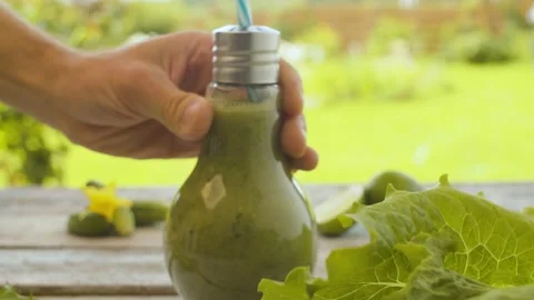 Hand putting bottle with smoothie on the table Stock Footage 137085048