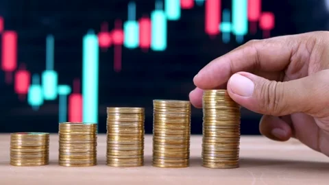 Hand putting coin on stack of coin against the price chart background Stock Footage 281139475