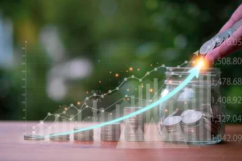 Hand putting coin stacking with virtual  trend graph on table. Stock Photos