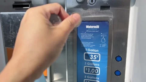 Hand Putting Coin into Water Refill Station Stock Footage 243701072
