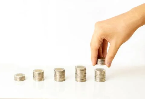 Hand putting coins to stack graph of coins on white background Stock Photos
