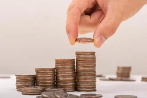 Hand putting coins on stack on table,Saving money concept or Business Growth  Stock Photos