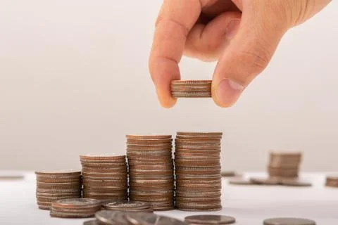 Hand putting coins on stack on table,Saving money concept or Business Growth  Foto stock