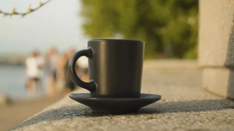 Hand putting cup of coffee on a granite parapet Vidéo 140426531