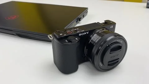 Hand putting doen SONY camera ZV-E10 on white table surface desk Stock Footage 250795841