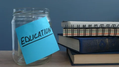 Hand putting dollar bills in jar with label education. Money for college. Stock Footage 86594085