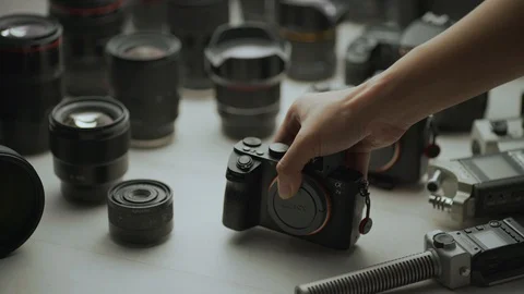 A hand putting down camera between another camera and lens. Video stock 128406270