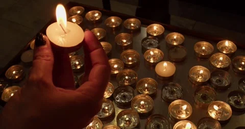 A hand putting down a candle in an old Italian church in Pisa 스톡 동영상 293808807