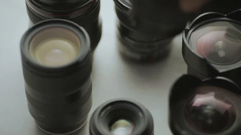 A hand putting down the lens of the camera between another lens.  Video stock 128407277