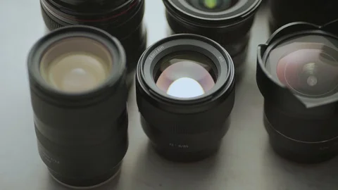 A hand putting down the lens of the camera between another lens. tools of trade  Video stock 128407321