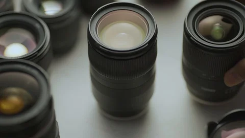 A hand putting down the lens of the camera between another lens. Video stock 128407517