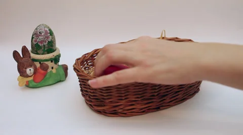 Hand putting Easter eggs in a basket, vintage metal egg in a bunny egg holder Stock Footage 35926312