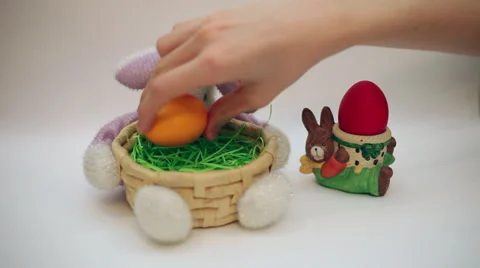 Hand putting Easter eggs in bunny basket decoration, bunny egg holder Stock Footage 35794061