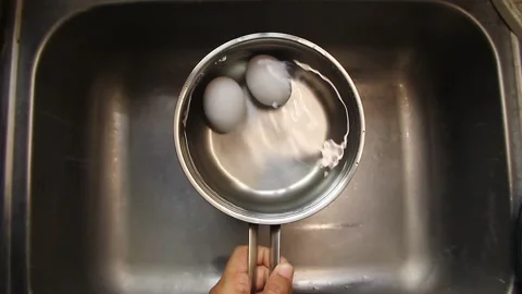 Hand putting eggs in a pan with water. Stock Footage 338078439