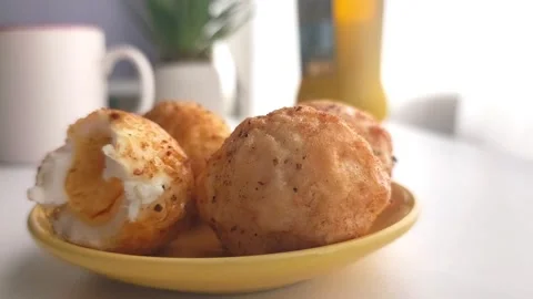 Hand putting a half-eaten fried boiled egg back on a yellow plate. Vídeos de archivo 334700367