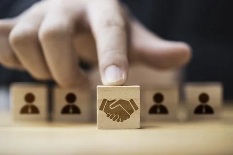 Hand putting hand shaking which print screen on wooden cube block in front .. Stock Photos