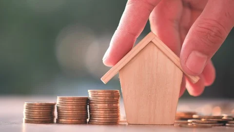 Hand putting house with Money coin on nature green background. Stock Footage
