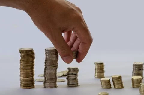 Hand putting money coins stack growing, saving money for purpose concept Stock Photos